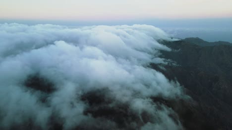 Filmic-View-of-Billowing-Clouds-on-Top-of-Mountain-Peak,-Spain-Dusk