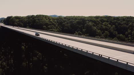 Jeep-car-cross-The-New-River-Gorge-Bridge,-Smooth-aerial-tracking-shot