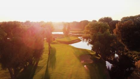 Aerial,-Landspace-Drone-Shot-Above-Golf-Course-Flying-Down-During-Sunny-Sunset-in-Warsaw,-Poland