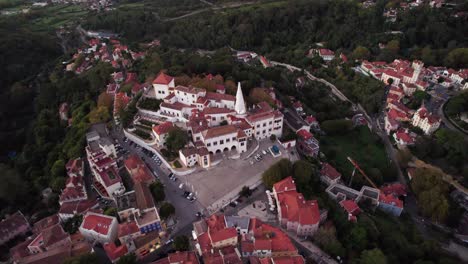 Cinematic-aerial-drone-shot-circling-around-old-Sintra-town-and-revealing-the-beautiful-landscape-surrounded-by-trees,-Lisbon,-Portugal