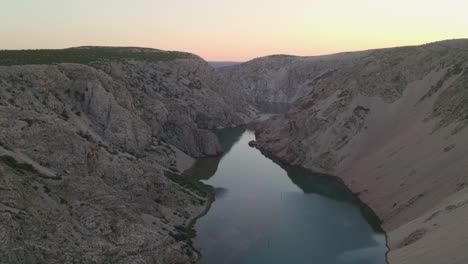 closeup-of-man-watching-Zrmanja-river-above-canyon-at-sunset,-Croatia