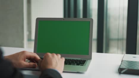 Male-hands-flipping-the-touchpad-of-a-laptop-with-a-chroma-key-on-the-screen