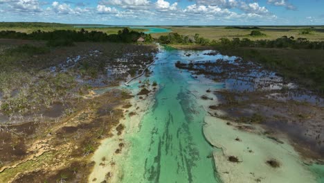 Aerial-view-approaching-people-enjoying-a-warm-day-at-the-Bacalar-rapids,-in-sunny-Mexico