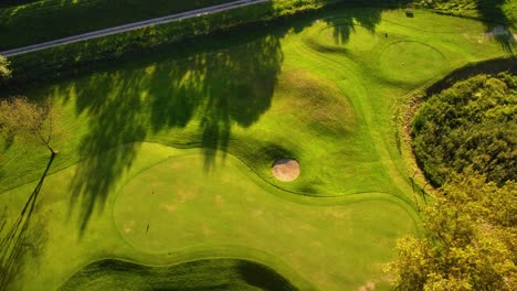 High-Angle-Aerial-Orbit-Rotation-Drone-Shot-Flying-Above-Green-Golf-Course-During-Sunny-Summer-Day