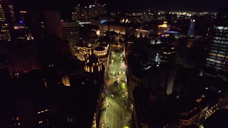 Dolly-in-aerial-view-of-the-chaotic-city-of-Buenos-Aires-at-night-with-the-representative-architecture-of-the-rooftops-of-the-ICBC-bank-headquarters-and-the-Bencich-building