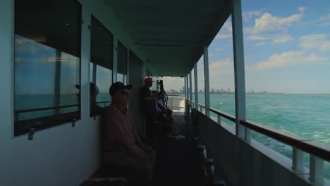 Männer-Sitzen-An-Der-Seite-Des-Bootes-Und-Nehmen-Sie-Mit-Der-Wunderschönen-Skyline-Von-Chicago-Hinter-Sich-Ins-Meer