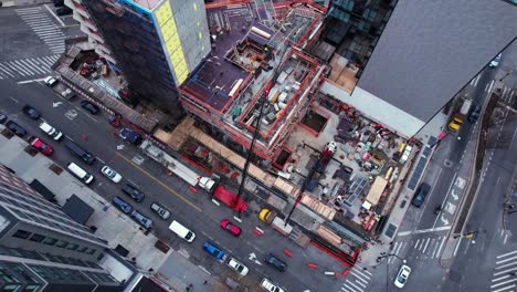 Aerial-overview-of-people-working-at-a-urban-construction-site-in-USA---high-angle,-orbit,-drone-shot