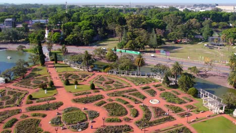 Aerial-view-low-dolly-in-the-Palermo-Rose-Garden,-design-of-the-park-and-the-color-of-its-ground-with-the-flowers-around,-sunny-spring-day,-Buenos-Aires