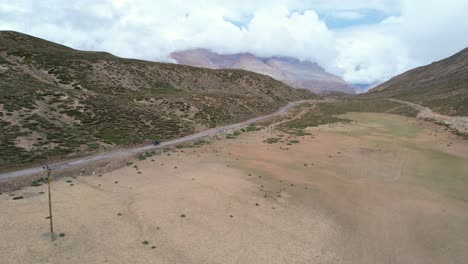 Trípode-Aéreo-Estático-De-Motociclista-Conduciendo-Por-Un-Camino-De-Tierra-En-Las-Montañas-Del-Valle-De-Spiti-India