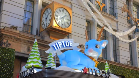 Iconic-Clock-And-Tiptoe-The-Blue-Reindeer-Decoration-On-The-Entrance-Of-Macy's-Herald-Square-During-Christmas-Time-In-New-York-City