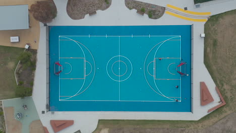 Aerial-static-perspective-of-young-people-practicing-basketball-at-a-local-community-sports-precinct