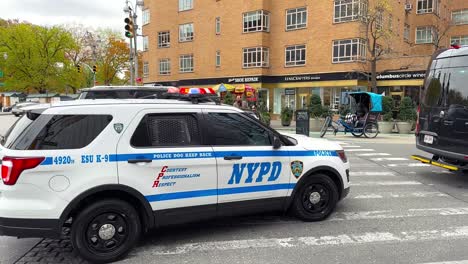 Großer-Schwarzer-Sicherheitswagen,-Der-Vorbeifährt,-Gefolgt-Von-Einem-Nypd-polizeiauto-In-New-York-City