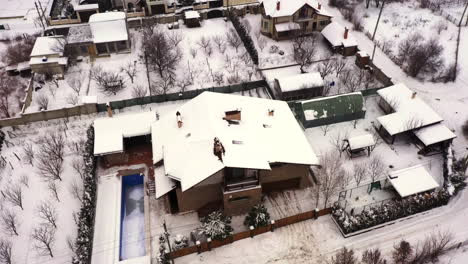 Drone-Aéreo-Volando-Sobre-Casa-Cubierto-De-Nieve