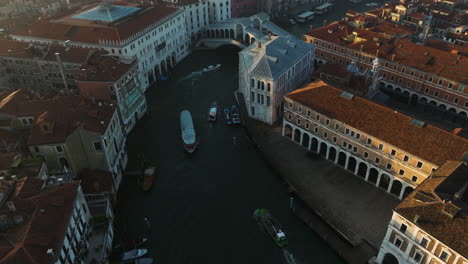 Ponte-Rialto-Crossing-Grand-Canal-In-Venice,-Italy---aerial-drone-shot