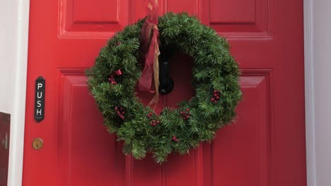 Green-Chrismas-Wreath-On-The-Red-Door-Of-Charles-Dickens-Museum-In-King's-Cross,-London-Borough-Of-Camden,-UK