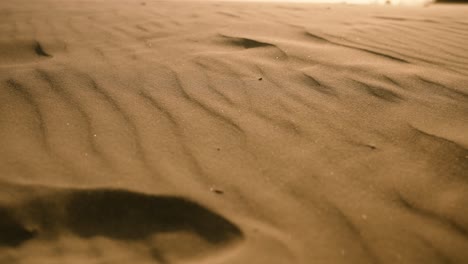 Wind-blows-ripples-in-sand-in-slow-motion-on-hot-sunny-day-in-the-desert-or-beach