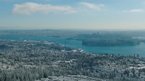 Wide-Drone-Aerial-View-of-Vancover-covered-in-snow-with-the-Lions-Gate-Bridge-in-the-distance