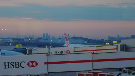 HSBC-loading-bridges-lead-to-planes-during-early-morning-with-the-cityscape-in-the-distance