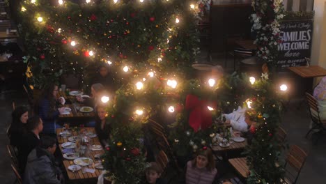 Hochwinkelaufnahme-Von-Einheimischen,-Die-Essen-In-Einem-Lokalen-Food-Court-In-Covent-Garden-Genießen,-Das-Mit-Weihnachtsdekorationen-In-London,-Großbritannien,-Bedeckt-Ist