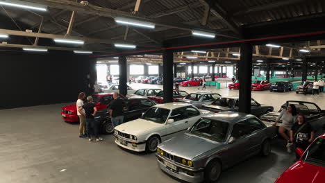 Indoor-car-meet-featuring-BMW-e30,-many-vintage-vehicles-in-vibrant-colors