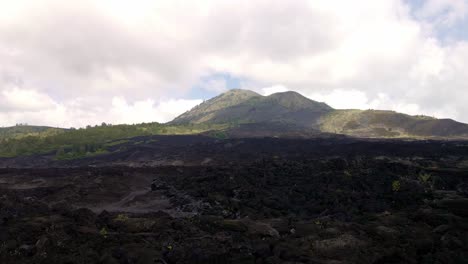 Volar-Sobre-Rocas-Volcánicas-Y-Campos-De-Lava-Cerca-Del-Monte-Batur,-Bali,-Indonesia