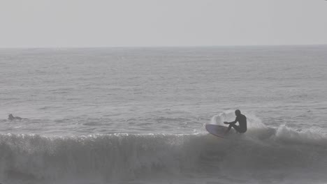 Surfer-man-surfs-the-wave-at-Carcavelos-surf-spot-in-Cascais