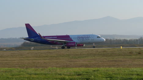Tracking-shot-of-Wizz-Air-plane-taking-off-at-Sibiu-airport-on-a-sunny-day,-Romania