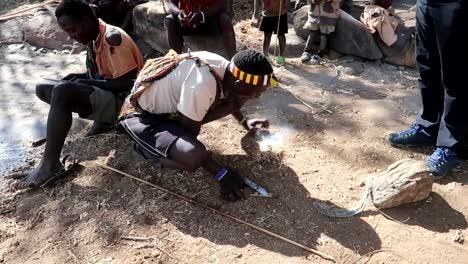 Tourists-learning-to-make-a-fire-with-a-Hadzabe-tribe-member-in-Tanzania,-Africa