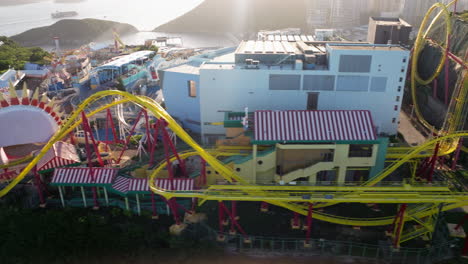 Aerial-sideways-shot-of-Hair-Raiser-rollercoaster-in-Ocean-Park-Hong-Kong-during-sunset-light