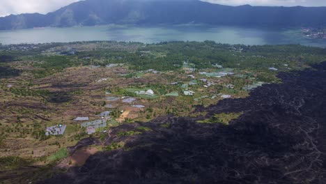 Aerial-View-Of-Lava-Field-Near-Agricultural-Land-In-The-Rural-Town-Of-Batur,-Bali-Indonesia