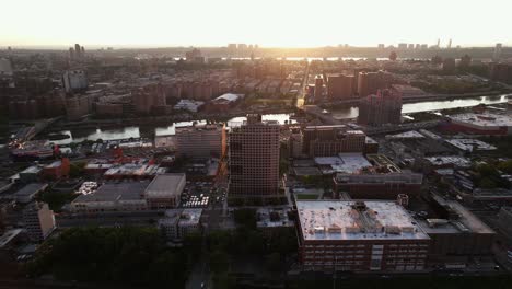 Aerial-view-over-the-Bronx-towards-the-Harlem-river-and-cityscape,-sunset-in-New-York,-USA