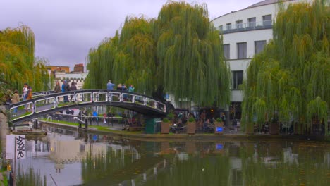 Gente-Haciendo-Turismo-Cruzando-El-Puente-Sobre-El-Canal-Regents-En-El-Famoso-Camden-Lock,-Londres,-Reino-Unido