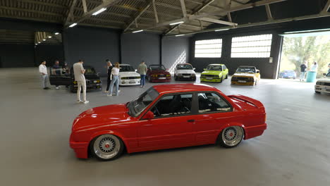 Classic-shiny-red-BMW-e30-parked-in-Barcelona-warehouse-fan-meeting-showcase