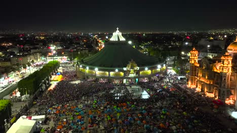 Aerial-view-over-people-gathered-to-worship-Saint-Mary-at-the-Plaza-Mariana-in-Guadalupe,-Mexico---rising,-reverse,-drone-shot
