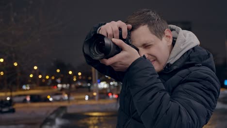 Legerer-Junger-Erwachsener,-Der-Nachtlebenfotos-In-Berliner-Straßen-Mit-Spiegelloser-Kamera-Macht,-Handaufnahme
