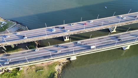 Drone-aerial-scene-of-the-Pedro-Ivo-Campos-and-Colombo-Salles-bridge-in-Florianópolis,-capital-of-Santa-Catarina,-with-intense-vehicle-traffic,-scene-at-high-altitude-with-urbanism-and-sea