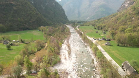Aerial-View-Of-Maggia-River-Flowing-Down-On-the-Village-Of-Bignasco,-Vallemaggia,-Canton-of-Ticino,-Switzerland