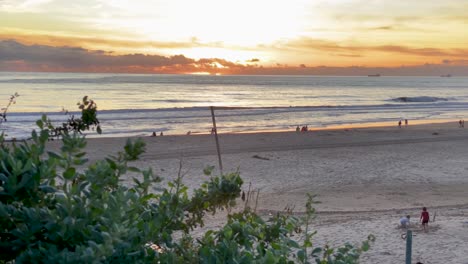 Einige-Glückliche-Menschen,-Die-Bei-Einem-Riesigen-Sonnenuntergang-Vor-Dem-Meer-Spazieren-Gehen