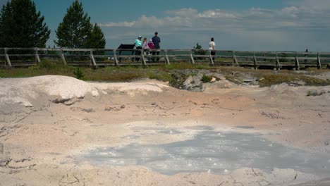 Geothermal-hot-spring-bubbling-with-people-watching-at-Yellowstone-national-park