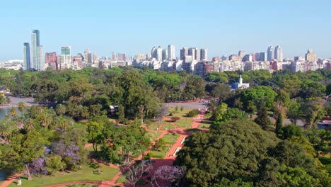 Aerial-orbit-in-contrast-with-the-Palermo's-Rosedal-park-and-the-Buenos-Aires-skyline-in-the-background-on-a-sunny-day