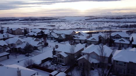 Fliegen-Mit-Drohne-über-Wintergemeinschaft-Während-Des-Sonnenuntergangs-Mit-Bergen-Im-Hintergrund