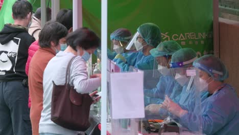 Chinese-residents-go-through-a-Covid-19-coronavirus-testing-process-outside-a-building-placed-under-lockdown-at-a-public-housing-complex-after-a-large-number-of-residents-tested-positive-in-Hong-Kong