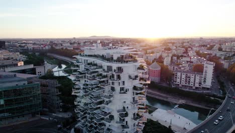 Spinning-aerial-shot-around-a-white-apartment-building-during-sunset-in-France