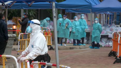 Police-officers-and-health-workers-wearing-PPE-suits-are-seen-standing-vigilant-outside-a-building-placed-under-lockdown-after-a-large-number-of-residents-tested-Covid-19-Coronavirus-positive