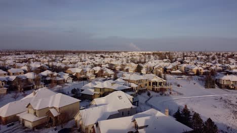 Drohnenaufnahme-Der-Mit-Schnee-Bedeckten-Häuser-Während-Der-Sonnenuntergangszeit-Der-Goldenen-Stunde