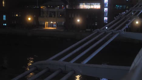 Nahaufnahme-Der-Seitlichen-Details-Der-Millennium-Bridge-Mit-Blick-Auf-Die-Themse-Unten-In-London,-England,-Großbritannien-Bei-Nacht
