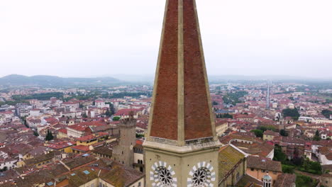 Drone-Orbiting-On-The-Iconic-Bell-Tower-Of-Arezzo-Cathedral-Overlooking-Cityscape-In-Tuscany,-Italy