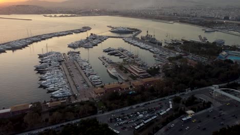 An-stunning-drone-shot-of-approaching-the-Floisvos-Marina-during-a-beautiful-sunset-in-Athens,-Greece