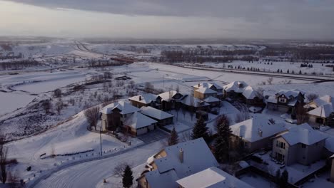 Flying-over-community-covered-in-snow-in-winter-time