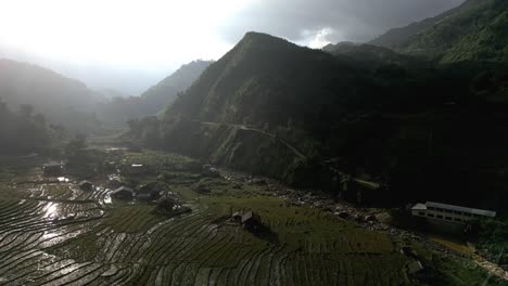 Magical-aerial-of-wet-rice-fields-in-the-mountains-somewhere-in-Asia-during-a-sunset-that-reflects-in-the-water